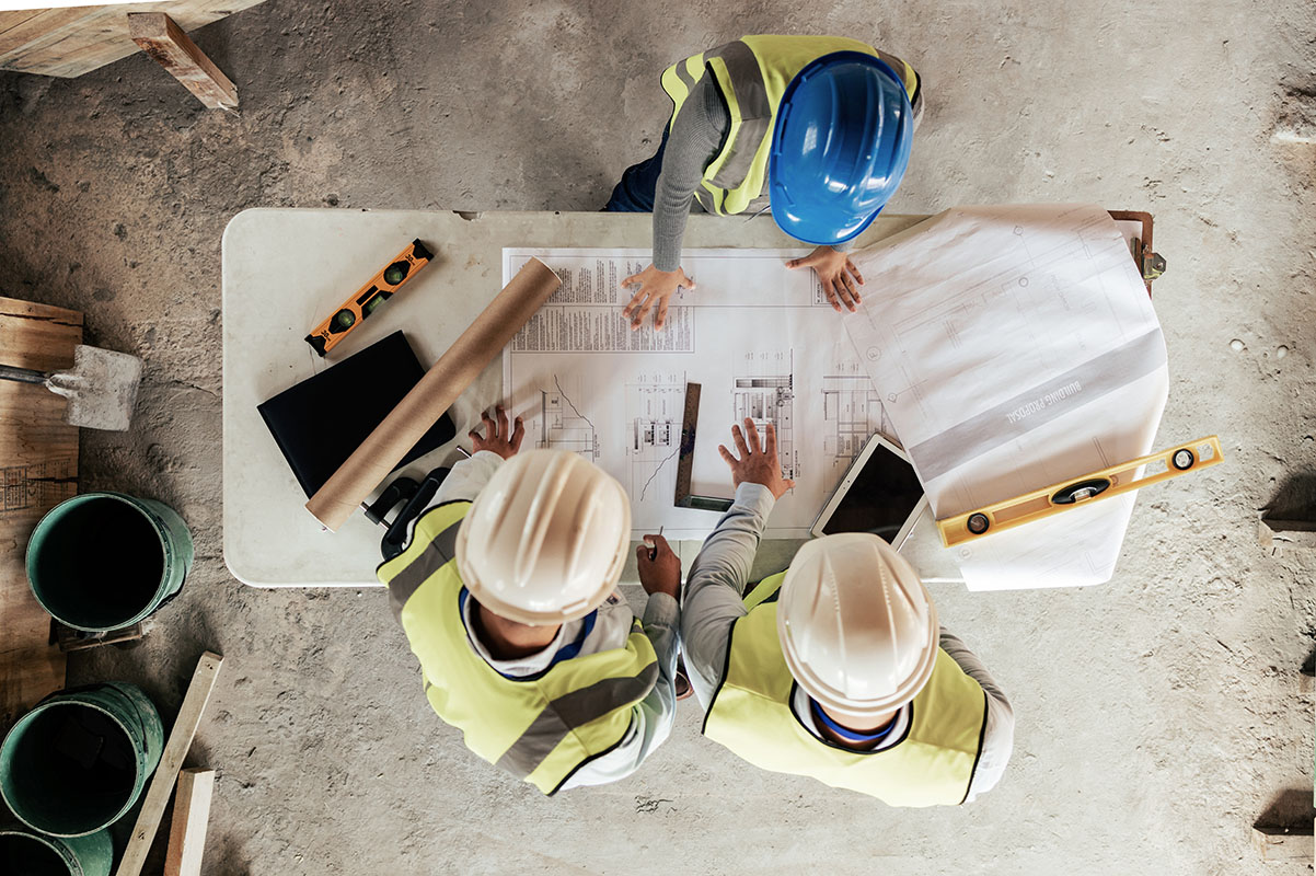 Professionnels étudiant les plans d'un chantier